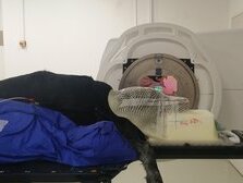 Lagerung mit Maske und Vakuumkissen während Conebeam-CT (im Hintergrund) und Bestrahlung
